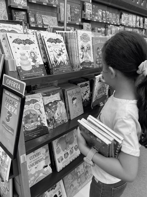 Girl holding books at a bookstore.